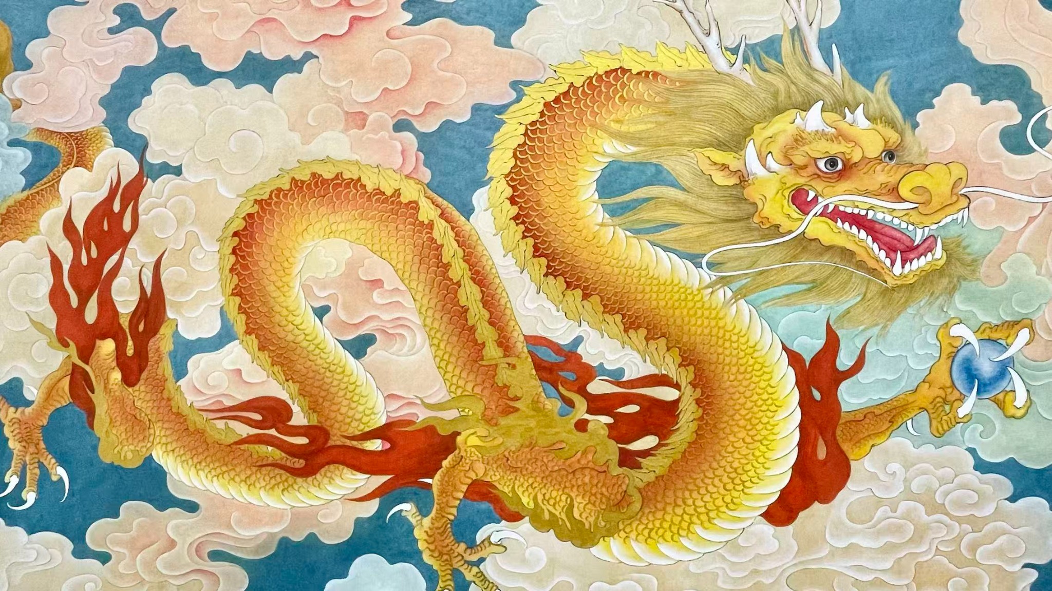 Unframed photograph of a horizontal golden dragon among clouds and red flames
